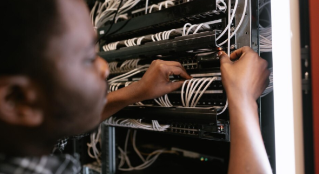 Technician working on network server installation in a data center Technician working on network server installation in a data center